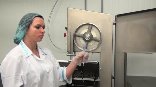 Mujer toma muestras para bacterias y microbios cerca de equipo de corte de carne. — Vídeos de Stock