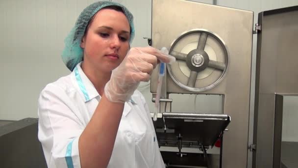 Woman takes samples for bacteria and microbes near meat cutting equipment. — Stock Video