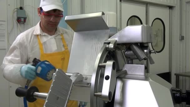 Man worker washes details of slicer for cutting sausage and cheese. — Stock Video