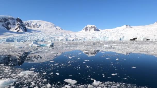 Una colina antártica a orillas del lago cubierta de cumbres de nieve. — Vídeos de Stock