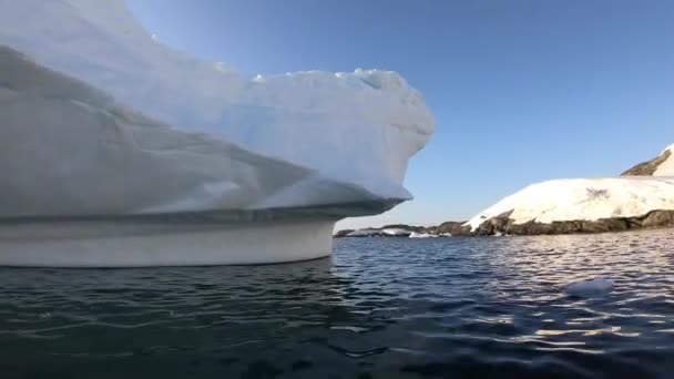 En roddbåt simmar runt ett isberg. — Stockvideo