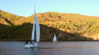 Türkiye 'de Deniz Koyu' ndaki güneş ışınlarından dağ kıyısının gölgesinde saklanan insanlar.