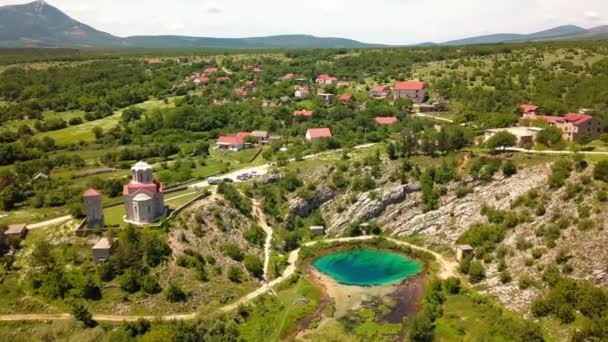 Jezero ve vesnici obklopené horami. — Stock video