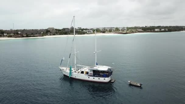 Velero flotando cerca de la orilla lijada blanca. — Vídeo de stock