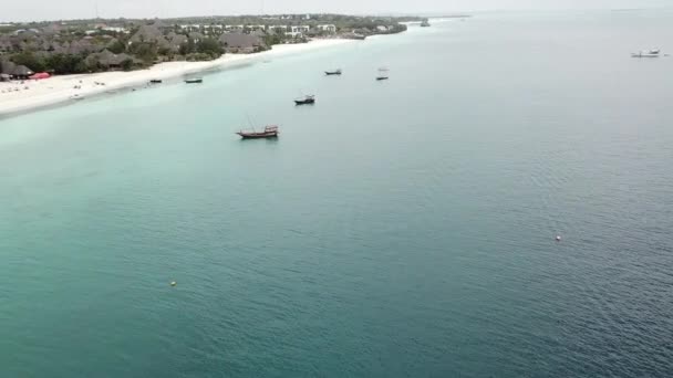 Bateaux flottant près d'un rivage sablonneux blanc. — Video