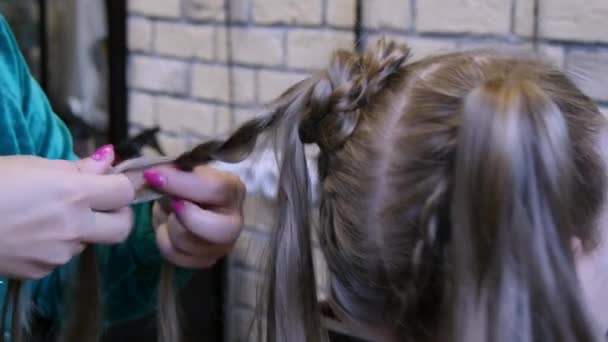 Manos de mujer tejen trenzas para niña. — Vídeos de Stock