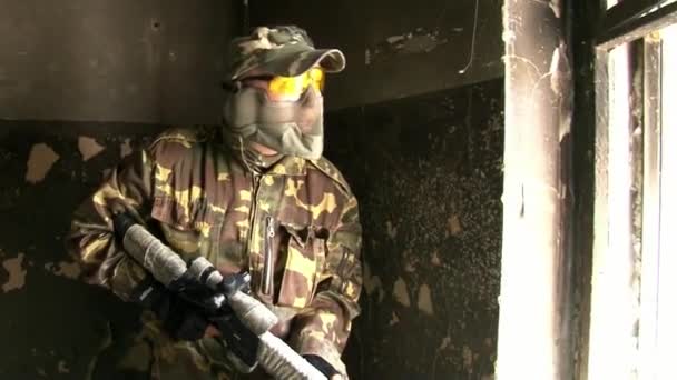 Airsoft hráč je na místě v zničeném domě. — Stock video