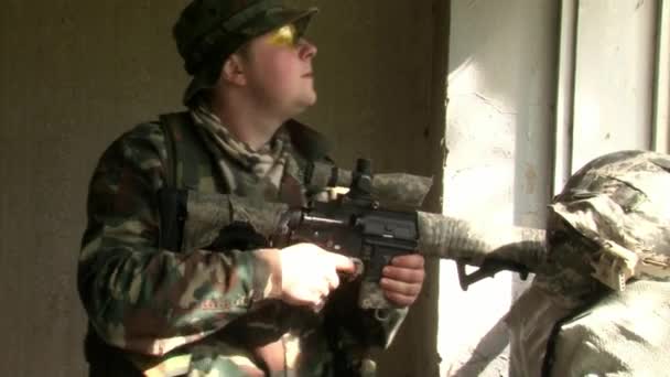 Airsoft player is in position is in position in a destroyed house. — Stock Video