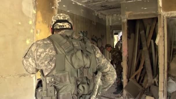 Игрок Airsoft находится в позиции в разрушенном доме. — стоковое видео