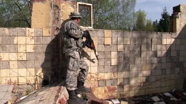 군용 다각형의 파괴된 건물에서 군복을 입고 노는 사람. — 비디오