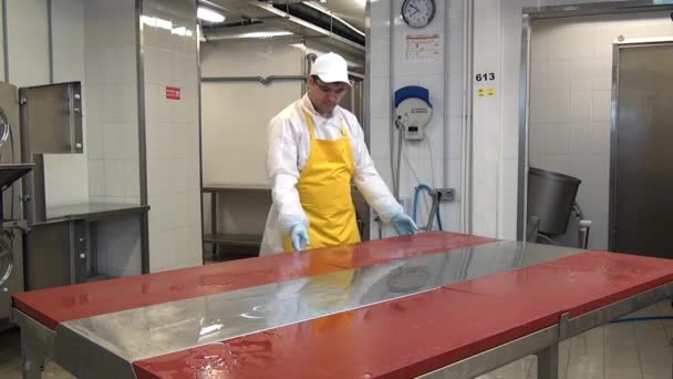 Homem desmonta uma mesa para lavagem e desinfecção em oficina industrial. — Vídeo de Stock