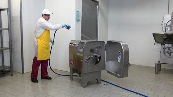 Pracownik myje i dezynfekuje maszynę do mielenia mięsa w warsztacie przemysłowym. — Wideo stockowe