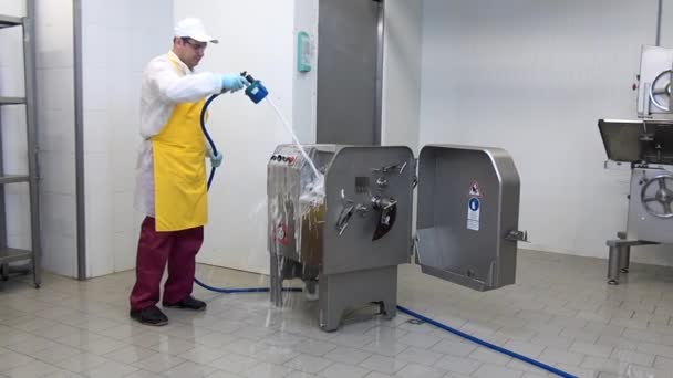 Homme travailleur lave avec de la mousse et désinfecte broyeur de viande dans l'atelier industriel. — Video