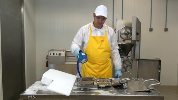 El trabajador del hombre lava y desinfecta las partes de la picadora de carne en el taller industrial. — Vídeo de stock