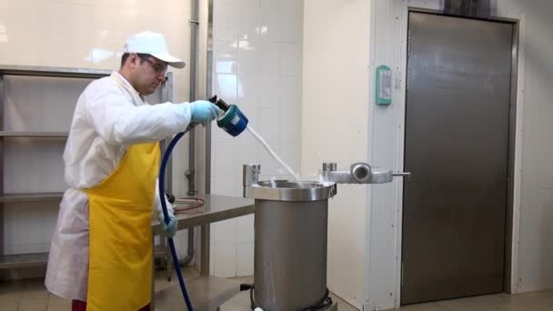 Man worker washes with foam industrial equipment for production of sausages. — Stock Video