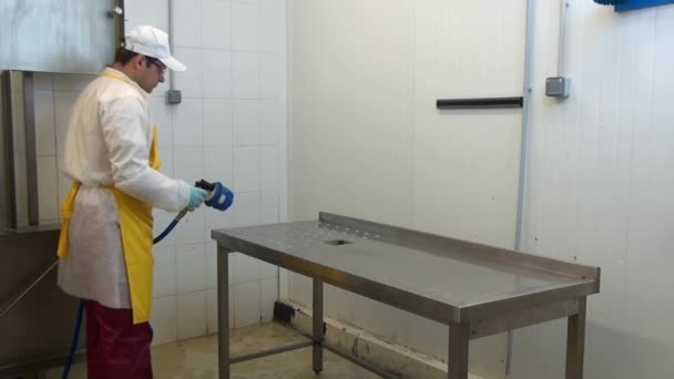 Homem trabalhador desinfecta tabela em oficina industrial. — Vídeo de Stock