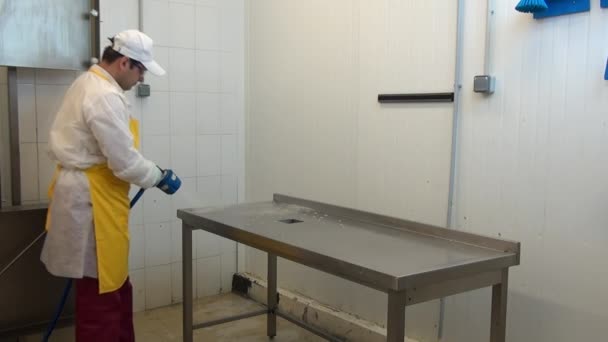 Hombre trabajador desinfecta mesa en taller industrial. — Vídeo de stock