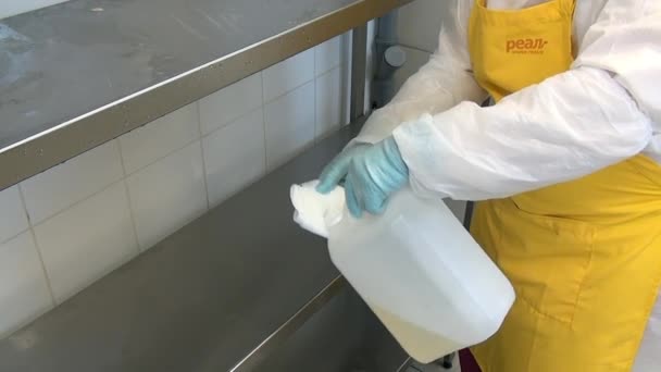 Człowiek pracownik dezynfekuje sprzęt spożywczy w warsztacie przemysłowym. — Wideo stockowe