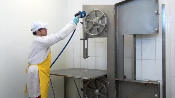 Homem trabalhador lavagens e detalhes de equipamentos de corte de carne na oficina industrial. — Vídeo de Stock