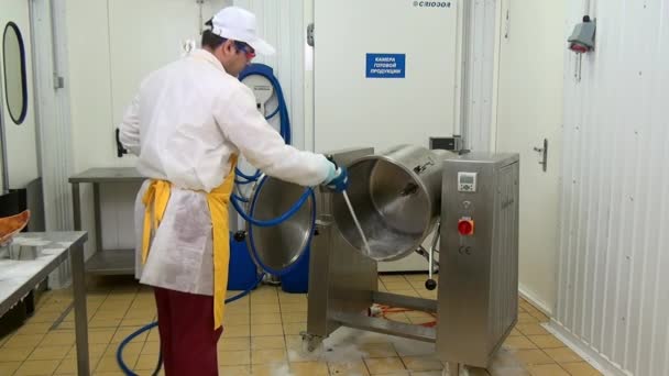 Homem lava equipamentos para misturar saladas usando equipamentos de lavagem industrial. — Vídeo de Stock