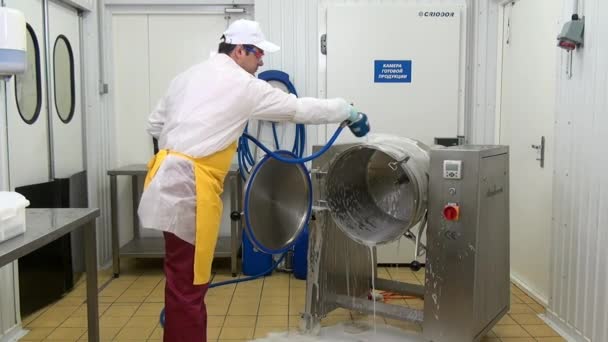 Homem lava equipamentos para misturar saladas usando equipamentos de lavagem industrial. — Vídeo de Stock