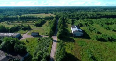 Arka planda gökyüzü ve çarpıcı manzara manzaralı bulutlarla çevrili bir nehir üzerinde evleri ve bahçeleri olan kırsal arazi aracı video panoraması. Açık hava iklimi kavramı.