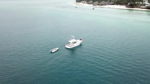 Barco flotando cerca de una orilla de arena blanca. — Vídeos de Stock