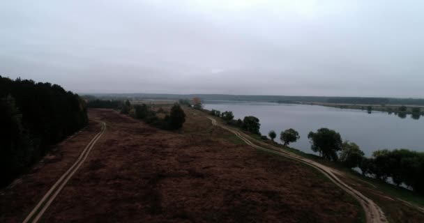 Drone luchtfoto panorama van het platteland met huizen en tuinen aan een rivier omgeven door achtergrond lucht en wolken met een prachtig landschap filmische uitzichten. Concept klimaat buiten natuur. — Stockvideo