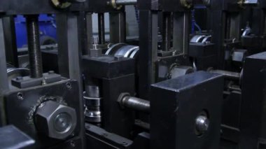 Yuvarlanan makinelerde paslanmaz çelikten metal şeritleri üretiliyor..