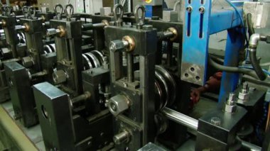 Fabrikadaki paslanmaz çelik boruların üretimi için makinelerde metalin bükülmesi.