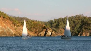 Türkiye 'de gölgede yattaki insanlar ve dağdaki güneş ışığı.