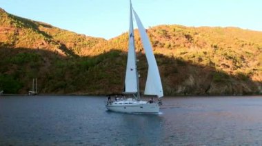 Türkiye 'de Deniz Koyu' ndaki güneş ışınlarından dağ kıyısının gölgesinde saklanan insanlar.