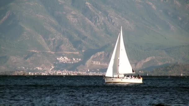 Lidé na jachtě na pozadí stínu a slunečního svitu na horách v Turecku. — Stock video