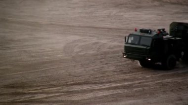 Rus askeri tankları ve teçhizatı tozlu yol boyunca ilerliyor.