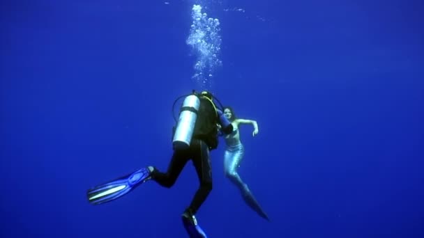 Young woman mermaid poses for camera of cameraman underwater in sea. — Stock Video