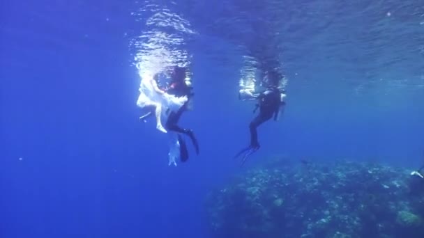 Engel jonge vrouw onderwater model in witte doek en cameraman. — Stockvideo