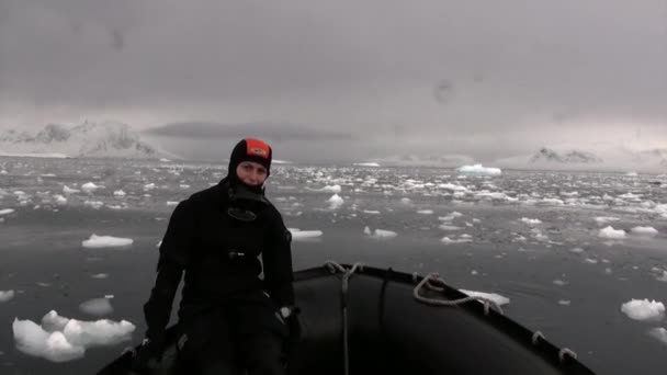 Menschen in Schlauchboot nahe Eisscholle und Eisberg des antarktischen Ozeans. — Stockvideo