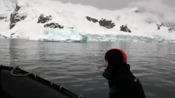 Άνθρωποι σε λαστιχένια βάρκα κοντά σε παγόβουνο και παγόβουνο της Ανταρκτικής. — Αρχείο Βίντεο
