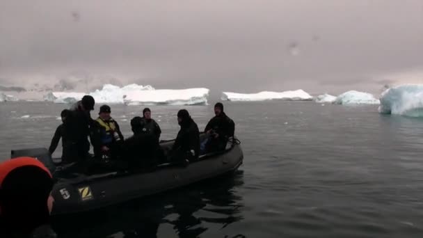 Mensen in rubberboot in de buurt van Ice floe en ijsberg van de oceaan Antarctica. — Stockvideo