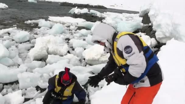 Άνθρωποι κοντά σε παγόβουνο στον ωκεανό της Ανταρκτικής. — Αρχείο Βίντεο