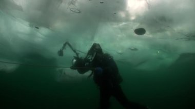 Baykal Gölü 'nün soğuk sularında buzun altında dalgıç kameraman..