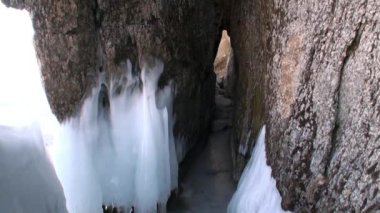 Baykal Gölü 'ndeki doğal buzulun kayaları üzerindeki büyük buz sarkıtları..