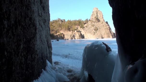 Baykal Gölü 'ndeki doğal buzulun kayaları üzerindeki büyük buz sarkıtları.. — Stok video