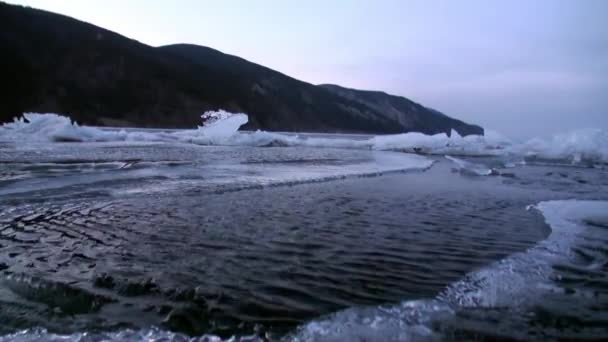 Zbliżenie dużych sopli lodowych na skałach naturalnego lodowca nad jeziorem Baikal. — Wideo stockowe