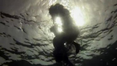 Mavi suyun arka planında beyaz giysili genç bir kadın..