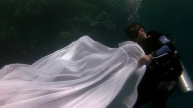 Mavi suyun arka planında beyaz giysili genç bir kadın..