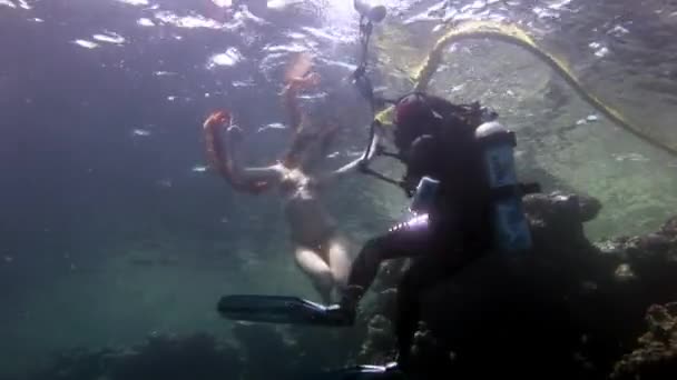 Kameraman skjuter video ung kvinna under vattnet modell. — Stockvideo