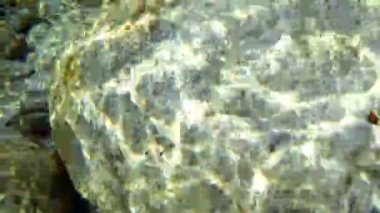 Verzaska Dağı 'nın poure suyunun altında, dipteki büyük pürüzsüz kayalar.