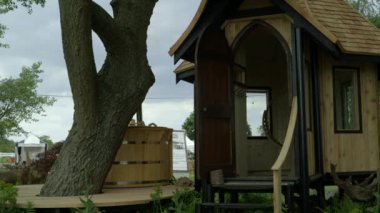 Bahar festivali RHS Malvern Hills 'te ağaç yakınlarındaki ahşap özel evin projesi ve tasarımı.