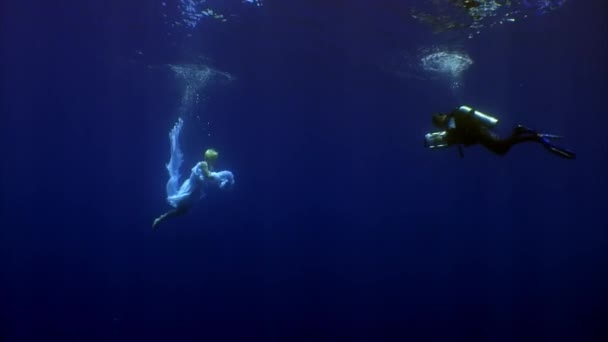 Angel joven modelo submarino en tela blanca y camarógrafo. — Vídeos de Stock